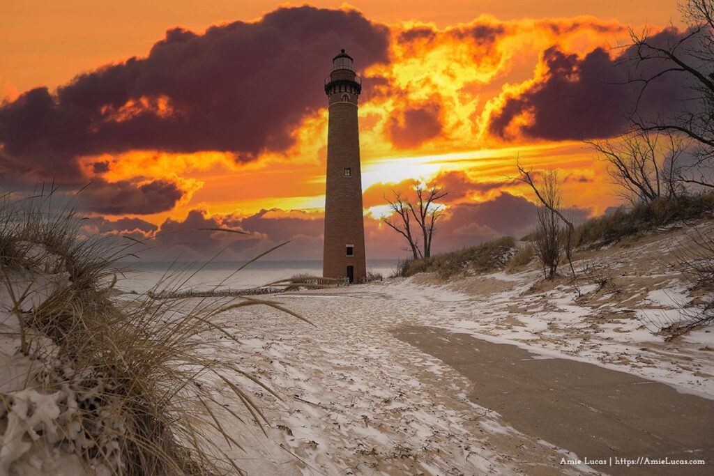 Little Sable Lighthouse in front a fiery sky during winter